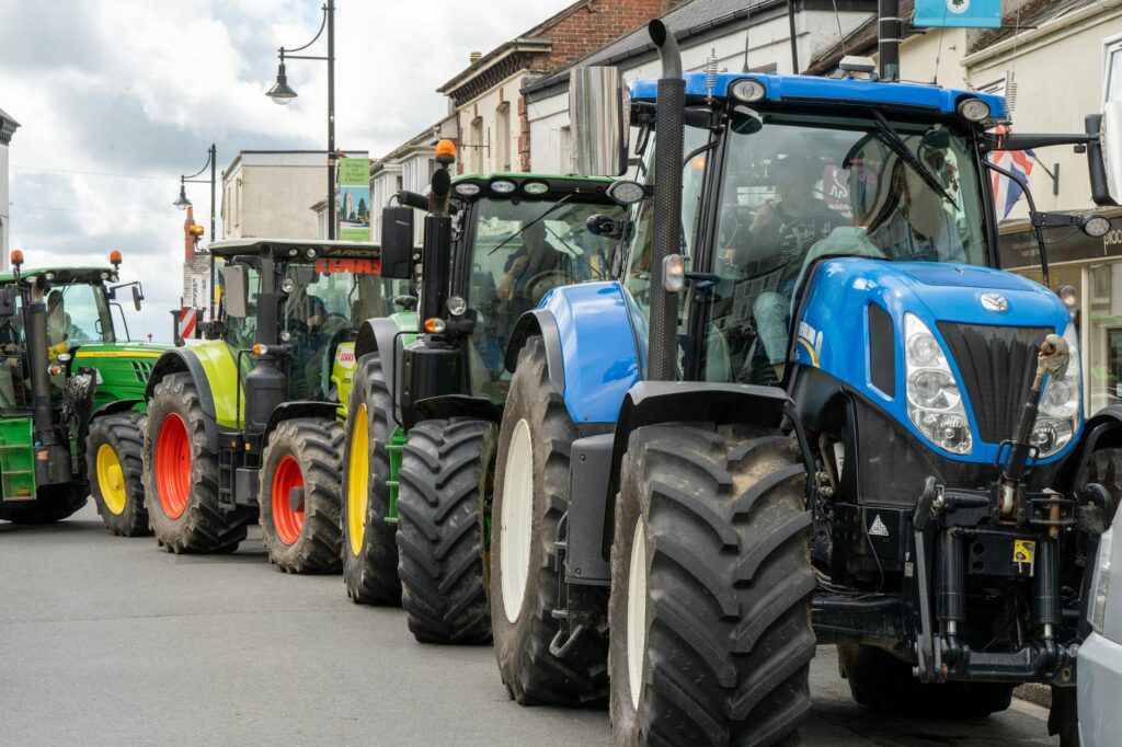 Lineup of vibrant tractors on a street in Holsworthy, England, showcasing agricultural machinery.